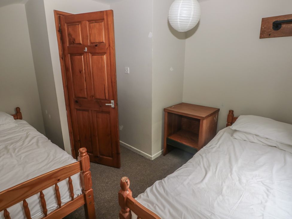 A bedroom with two beds and a nightstand at Cabin No. 4 - Salt and Fern Cabins Goytre near Port Talbot