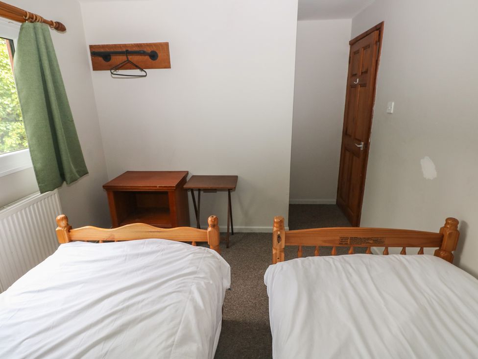 A bedroom with two beds and a table at Cabin No. 4 - Salt and Fern Cabins near Goytre
