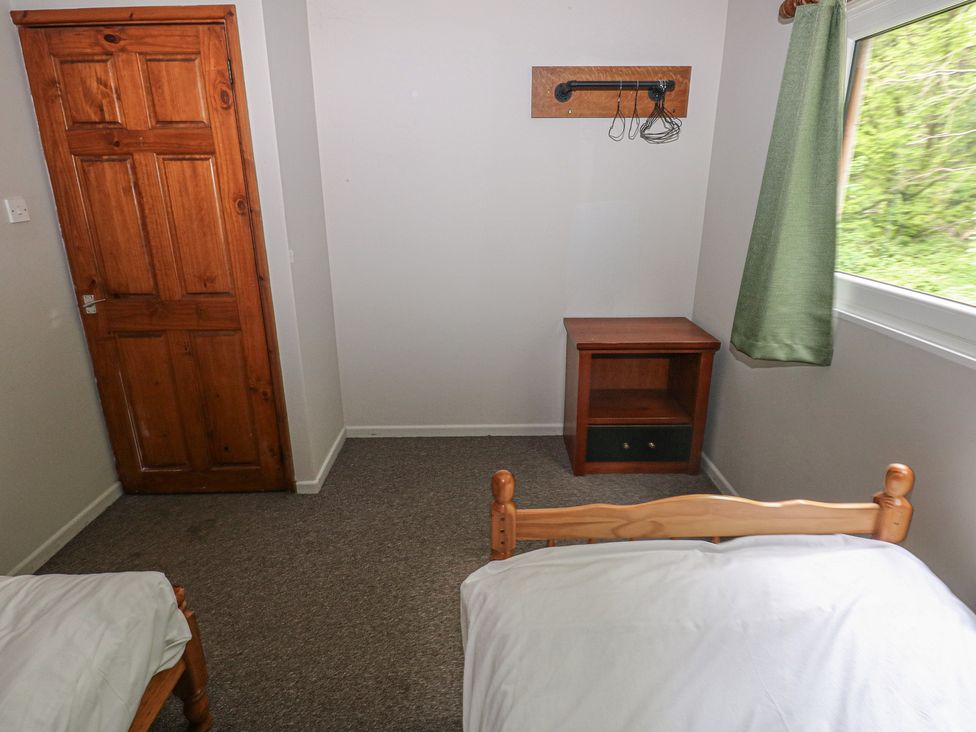 A bedroom with two beds and a nightstand at Cabin No. 4 - Salt and Fern Cabins in Goytre near Port Talbot