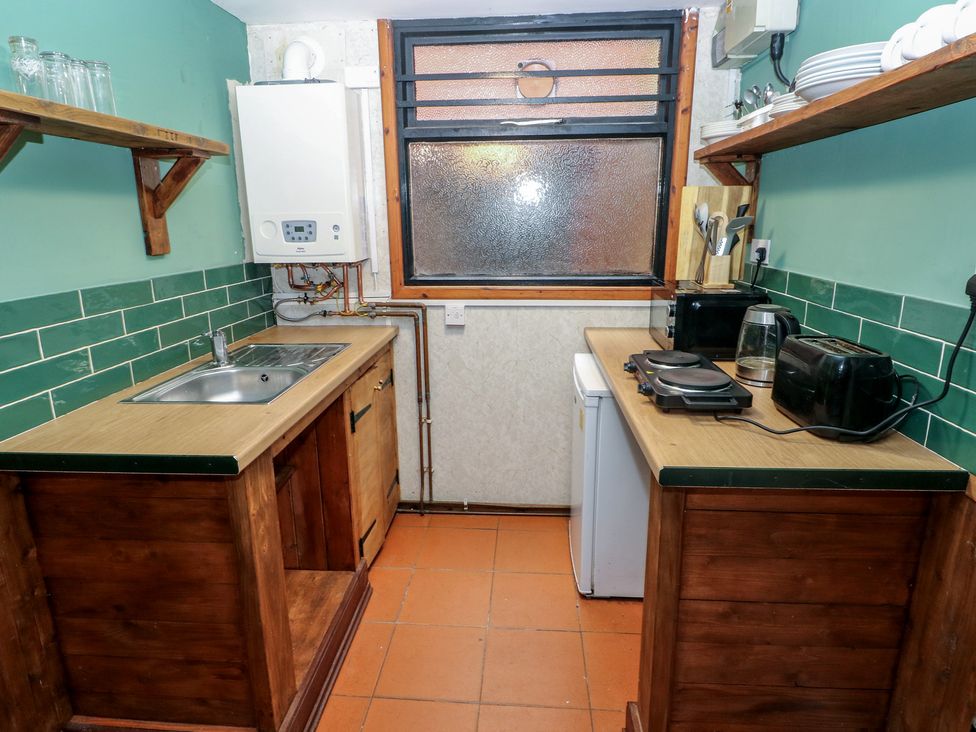 A kitchen with a sink and appliances at Cabin No. 5 - Salt and Fern Cabins Goytre near Port Talbot