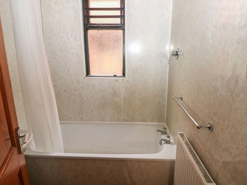 A bathroom with a bathtub and window at Cabin No. 5 - Salt and Fern Cabins in Goytre near Port Talbot
