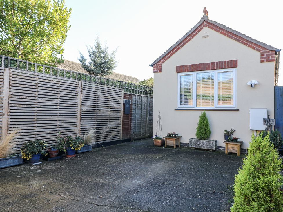 An outdoor area with a building and plants at The Garden Cottage in Hinckley