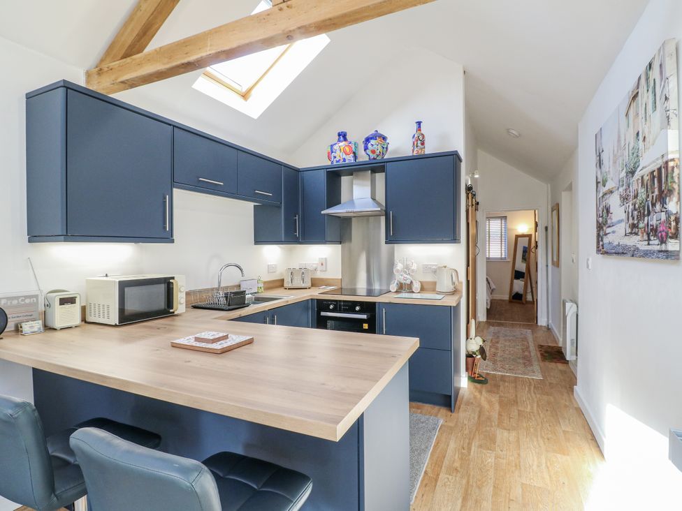A kitchen with cabinets and appliances at The Garden Cottage in Hinckley