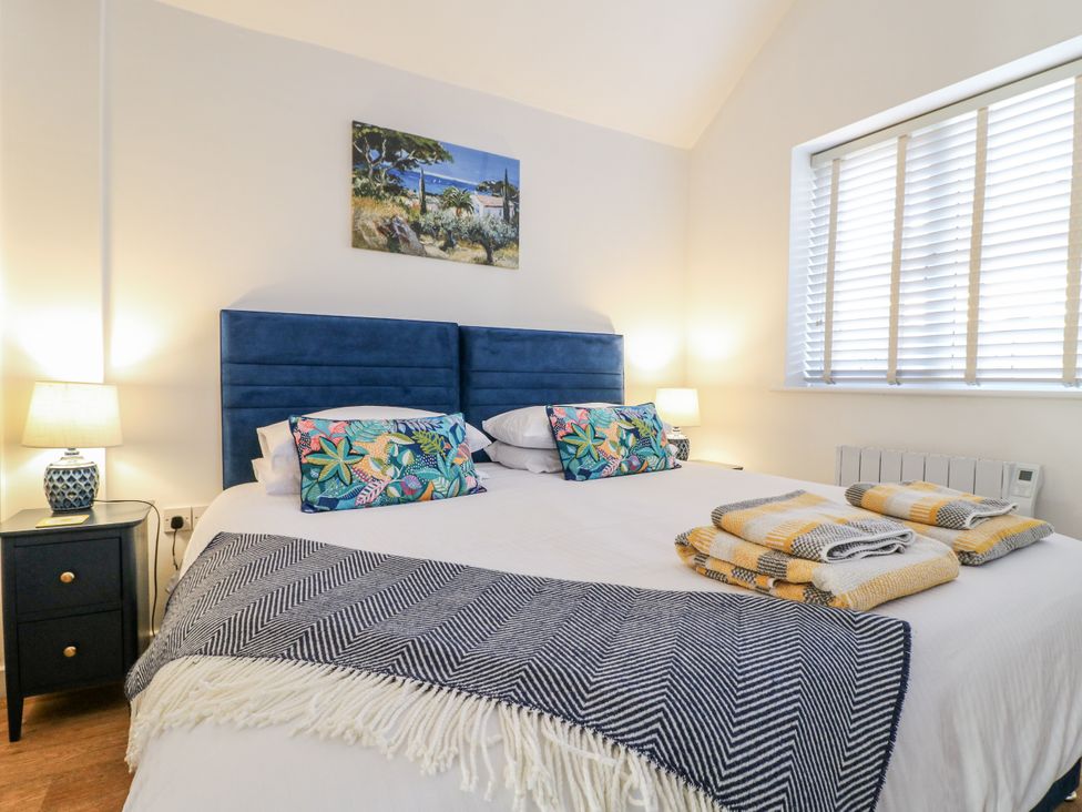 A bedroom with a bed and nightstand at The Garden Cottage in Hinckley