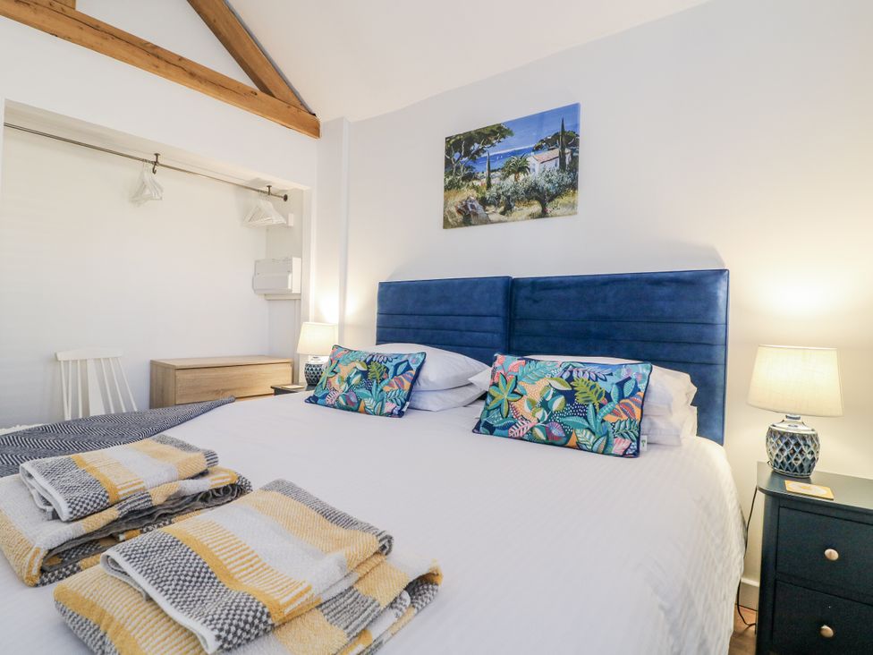 A bedroom with a bed and bedside table at The Garden Cottage in Hinckley