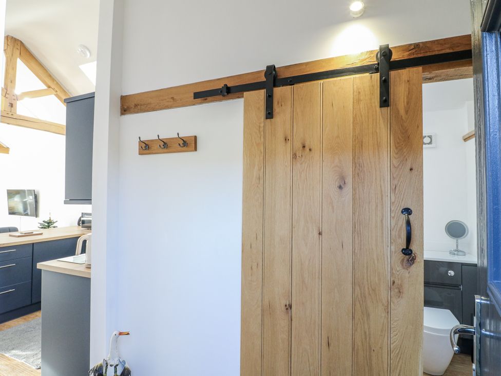 A bathroom with a sliding door and kitchen counter at The Garden Cottage in Hinckley