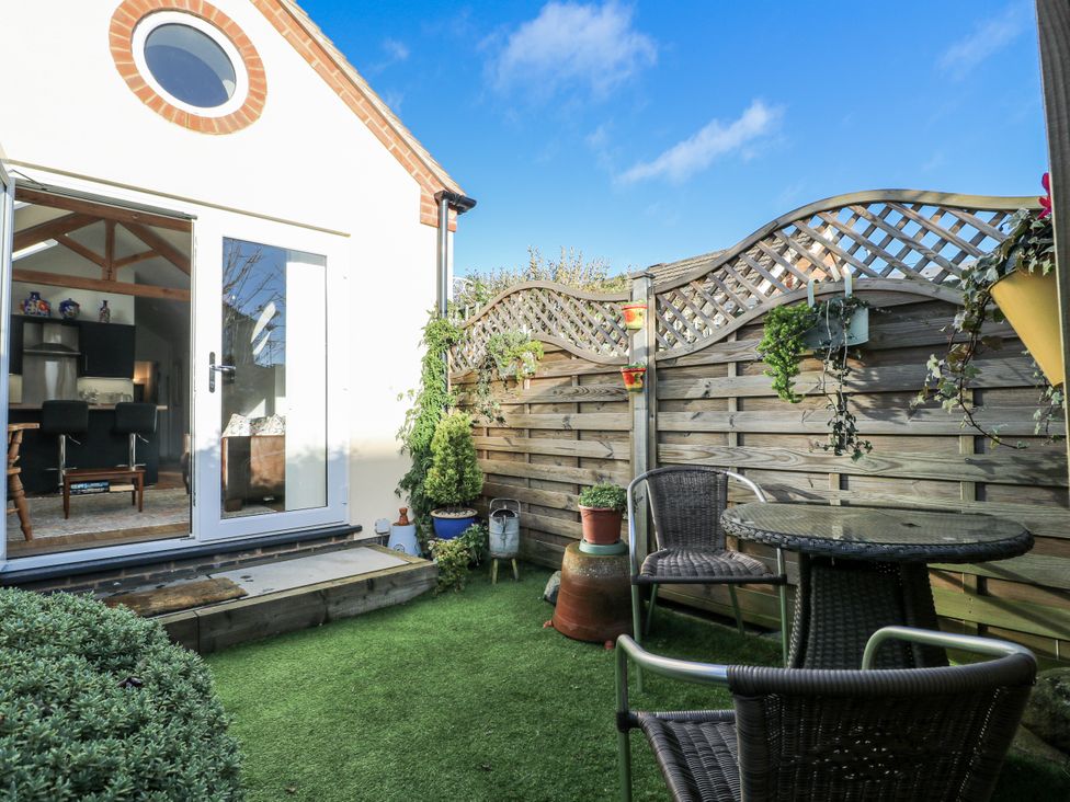 A garden with a table and chairs at The Garden Cottage in Hinckley