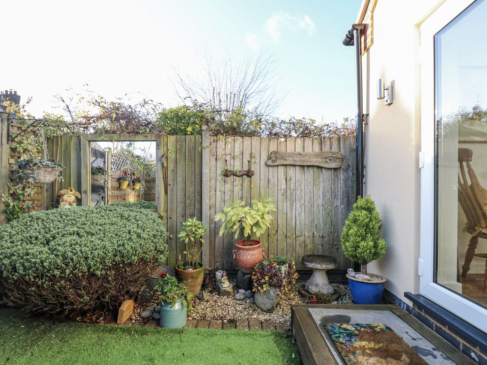A garden with plants and a wooden fence at The Garden Cottage in Hinckley