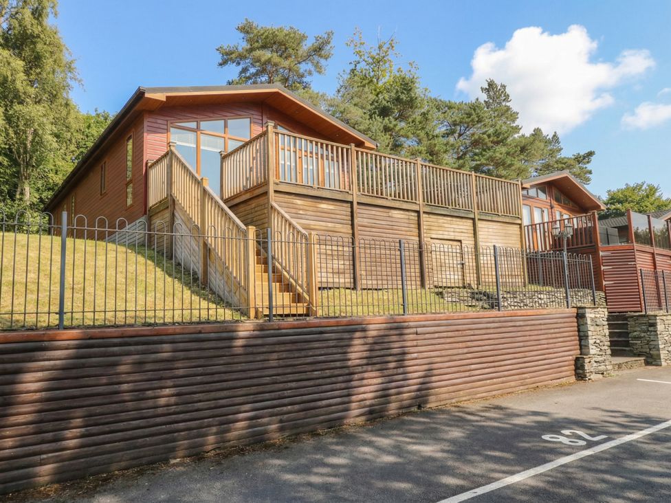 A house with a wooden deck and stairs at High Lake View Lodge White Cross Bay near Troutbeck Bridge