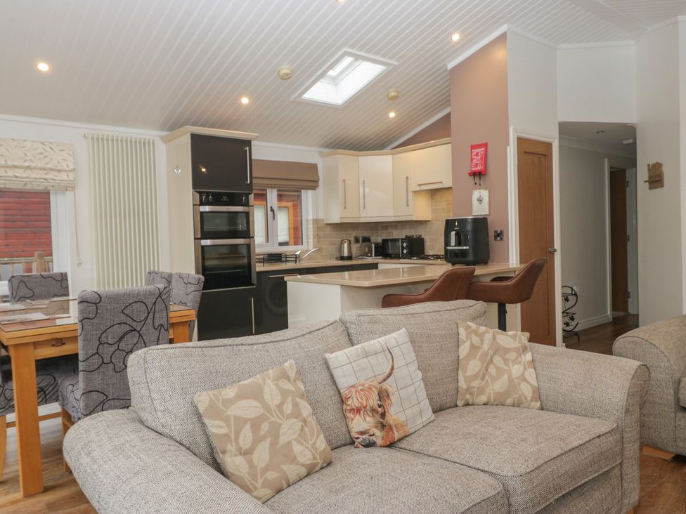 A kitchen with a dining area and sofa at High Lake View Lodge White Cross Bay near Troutbeck Bridge