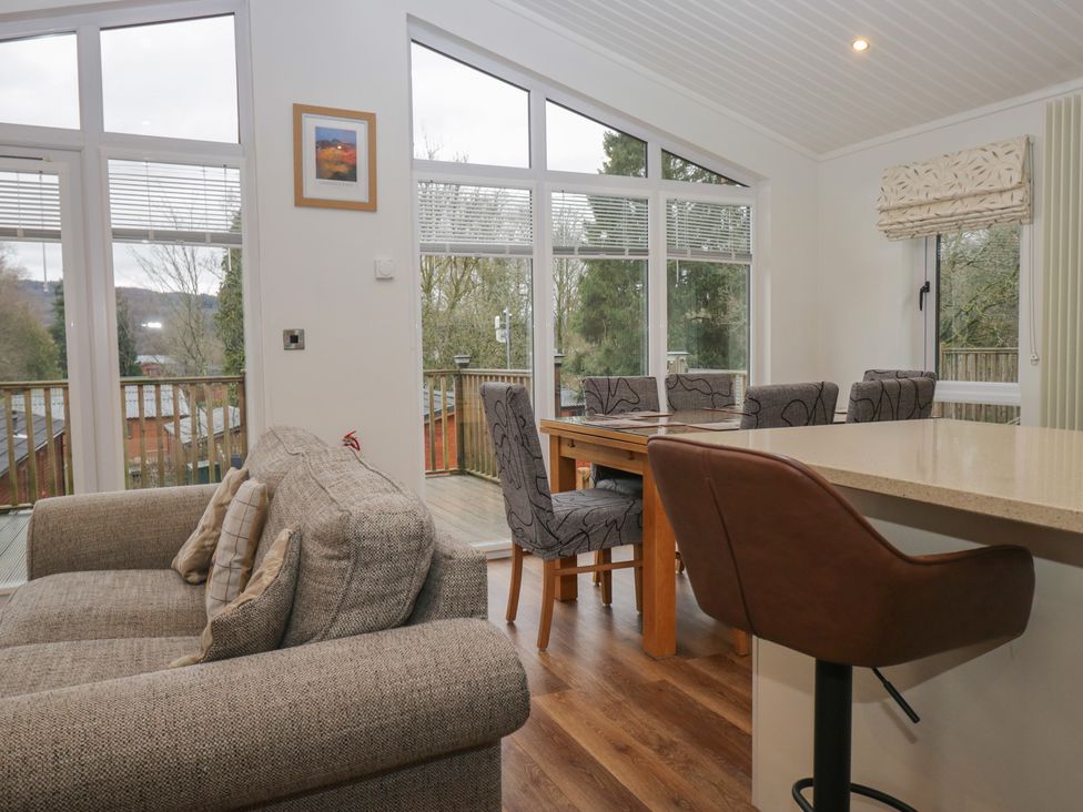 A living room with a sofa and dining area at High Lake View Lodge in White Cross Bay near Troutbeck Bridge
