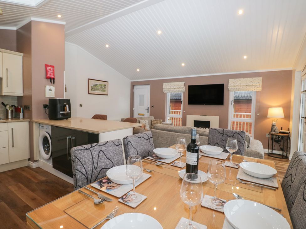 A living room with a dining table and kitchen units at High Lake View Lodge White Cross Bay near Troutbeck Bridge