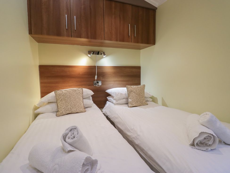 A bedroom with twin beds and a cushion at High Lake View Lodge White Cross Bay near Troutbeck Bridge