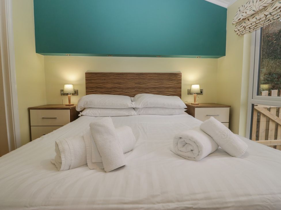 A bedroom with a bed and nightstands at High Lake View Lodge White Cross Bay near Troutbeck Bridge