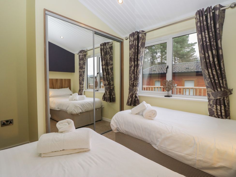 A bedroom with two beds and a window at High Lake View Lodge White Cross Bay near Troutbeck Bridge
