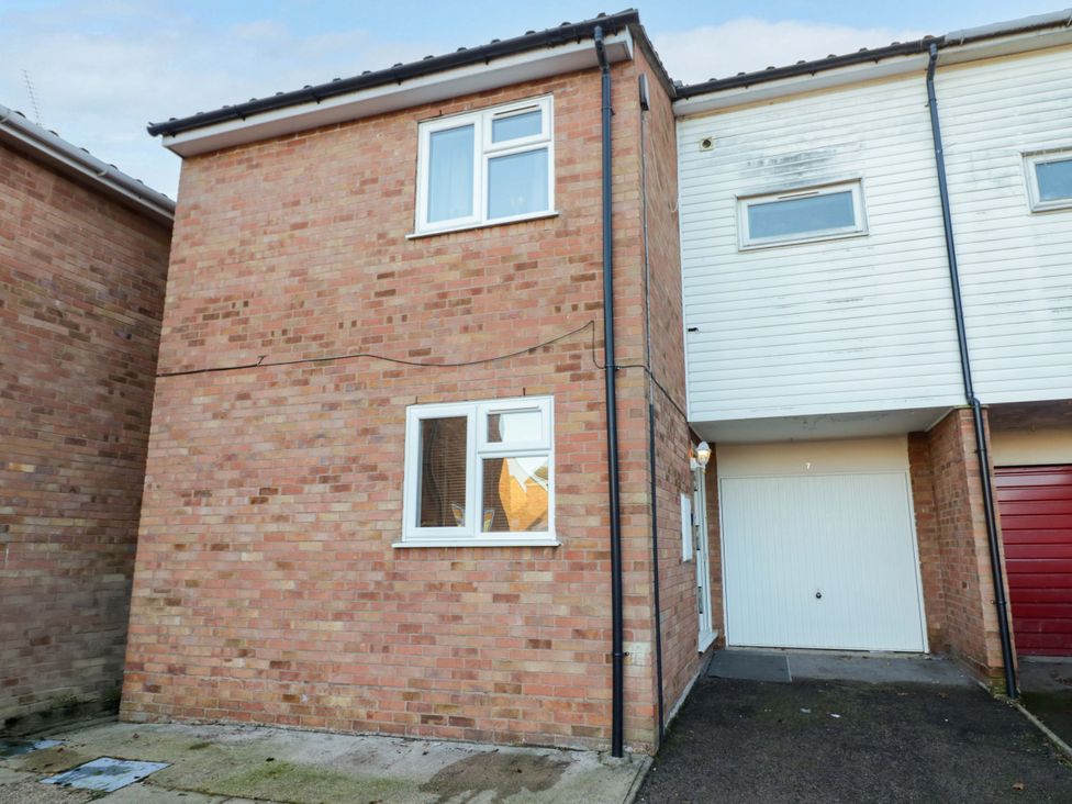 A brick facade of a house with garage door at 7 Waverton Mews Royal Leamington Spa
