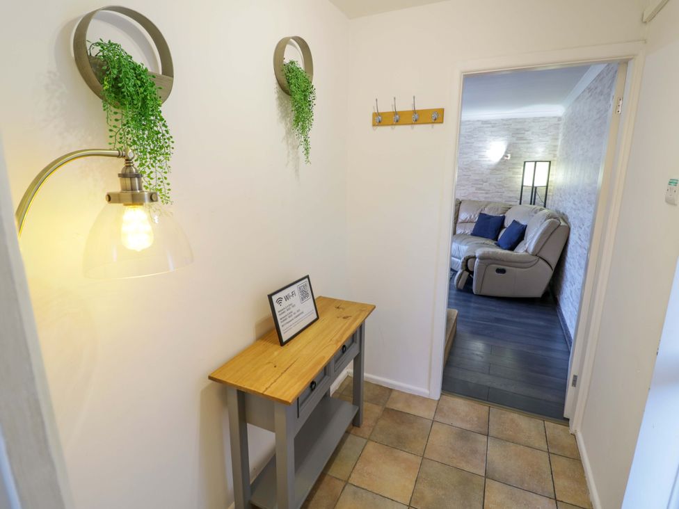 A hallway with a table and lamp at 7 Waverton Mews Royal Leamington Spa