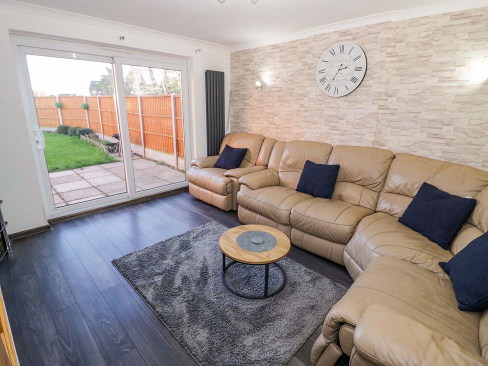 A living room with a leather sofa and coffee table at 7 Waverton Mews in Royal Leamington Spa