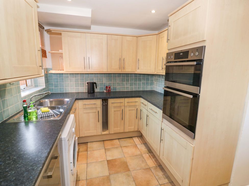 A kitchen with cabinets and appliances at 7 Waverton Mews Royal Leamington Spa