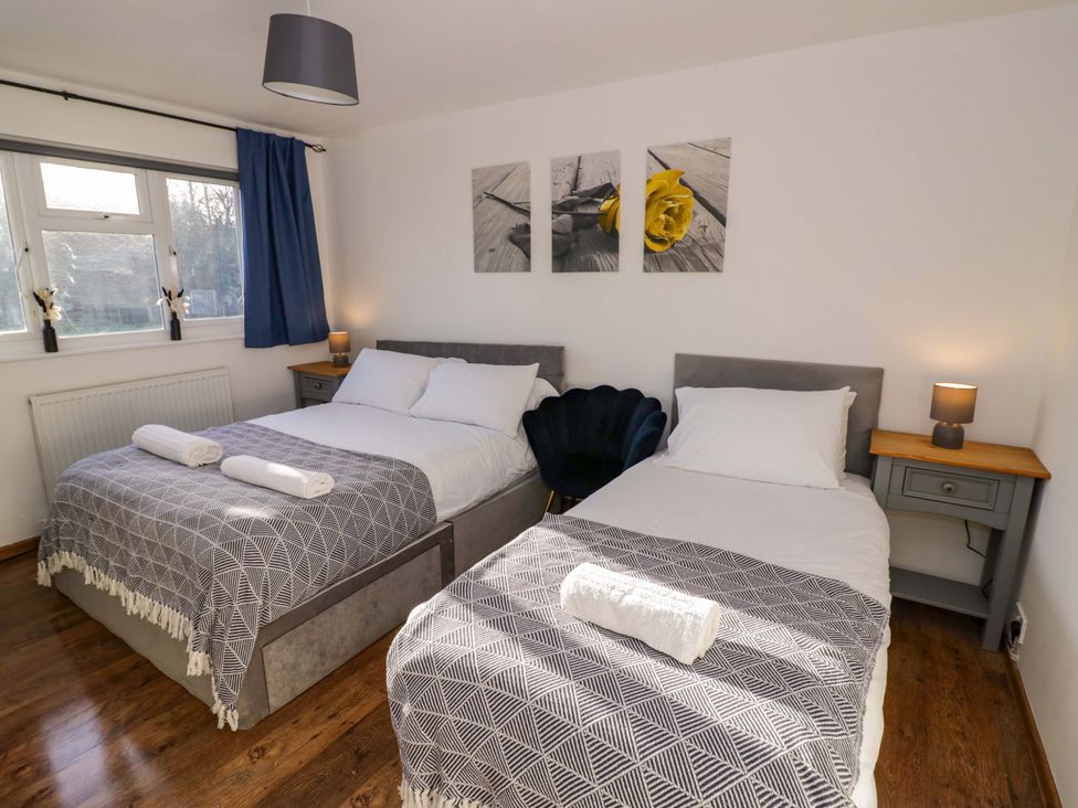 A bedroom with two beds and wall art at 7 Waverton Mews in Royal Leamington Spa