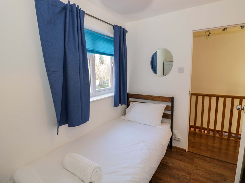 A bedroom with a single bed and a mirror at 7 Waverton Mews in Royal Leamington Spa
