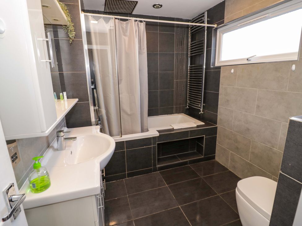 A bathroom with bathtub and sink at 7 Waverton Mews in Royal Leamington Spa