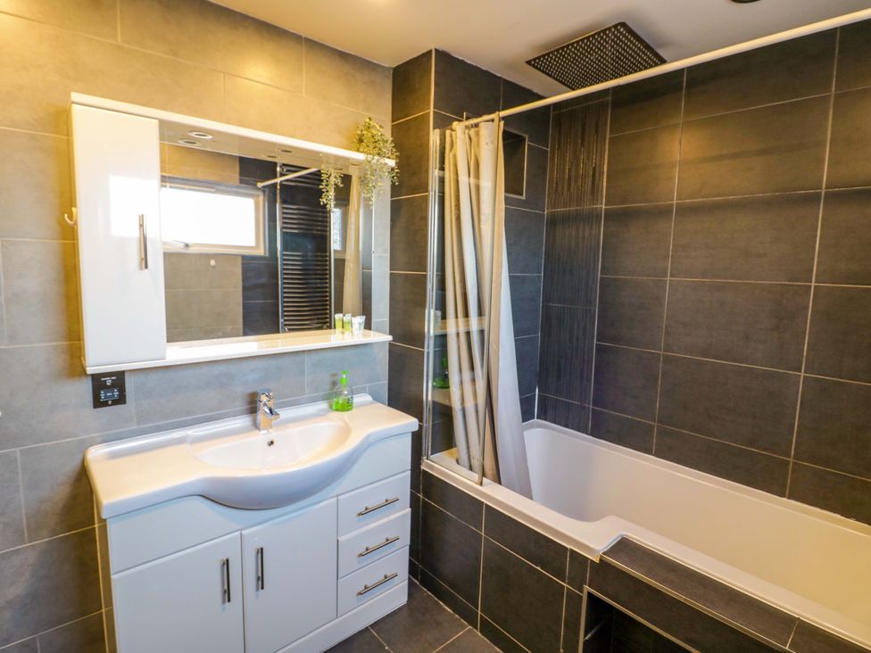 A bathroom with a bathtub and sink at 7 Waverton Mews Royal Leamington Spa