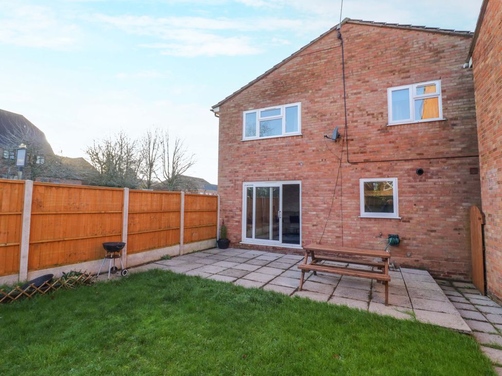 A garden with a table and fence at 7 Waverton Mews Royal Leamington Spa