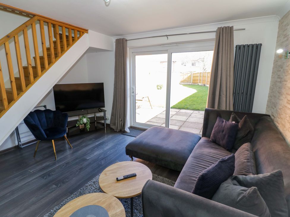 A living room with a sofa and television at 7 Waverton Mews in Royal Leamington Spa