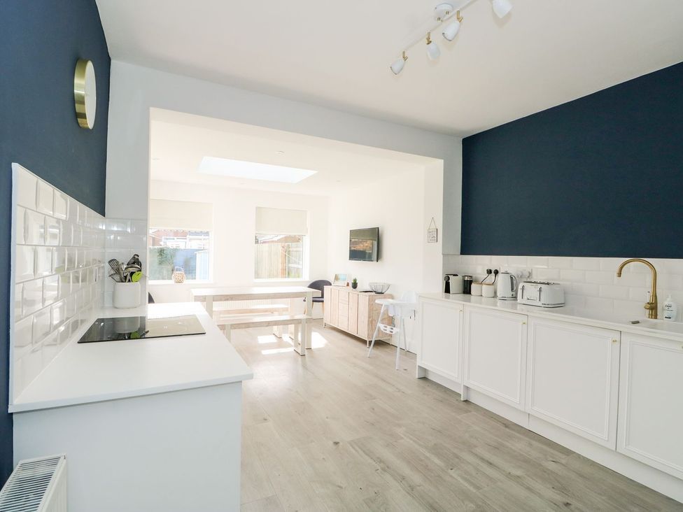 A kitchen with cabinets and a table at The Seaside Retreat in Mablethorpe