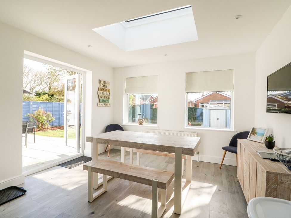 A dining room with a table and benches at The Seaside Retreat in Mablethorpe