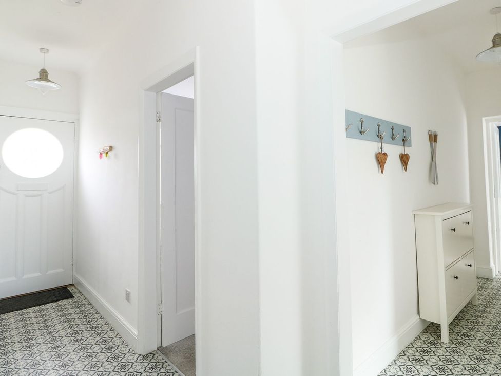 A hallway with a door and a cabinet at The Seaside Retreat in Mablethorpe