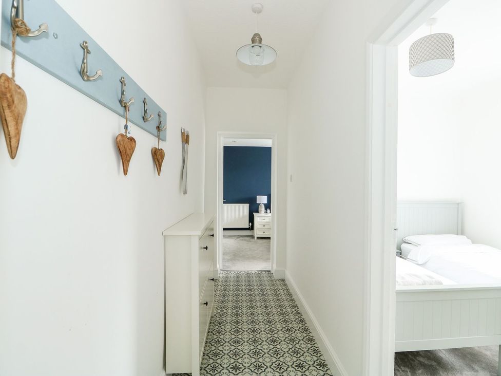A hallway with coat hooks and a cabinet at The Seaside Retreat in Mablethorpe