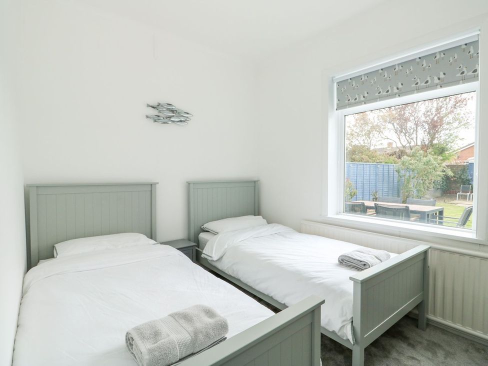 A bedroom with two single beds and a window at The Seaside Retreat in Mablethorpe