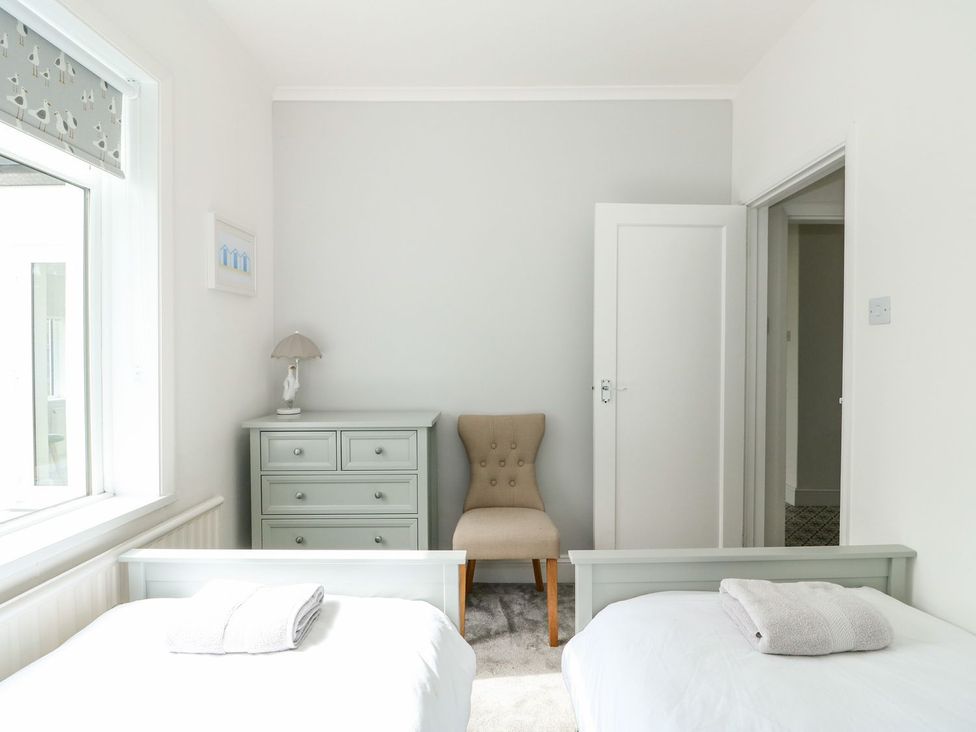 A bedroom with two beds and a chair at The Seaside Retreat in Mablethorpe