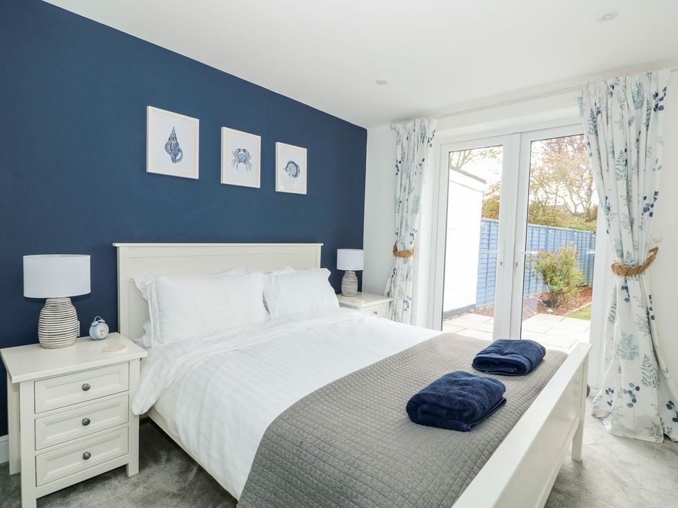 A bedroom with a bed and sliding door to the garden at The Seaside Retreat in Mablethorpe