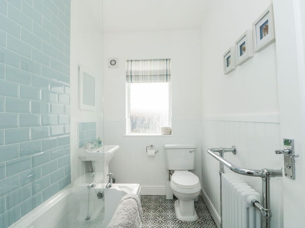A bathroom with a bathtub, toilet and sink at The Seaside Retreat in Mablethorpe