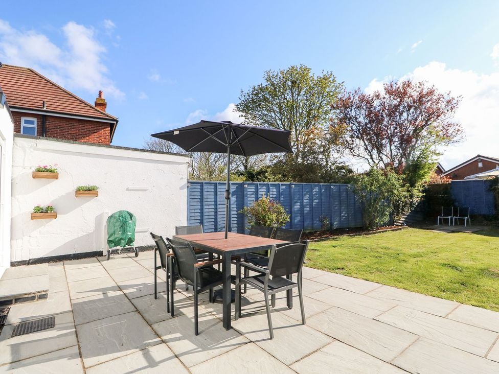 A garden with a table and chairs under an umbrella at The Seaside Retreat in Mablethorpe