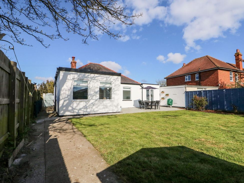 A garden with a house and patio furniture at The Seaside Retreat in Mablethorpe