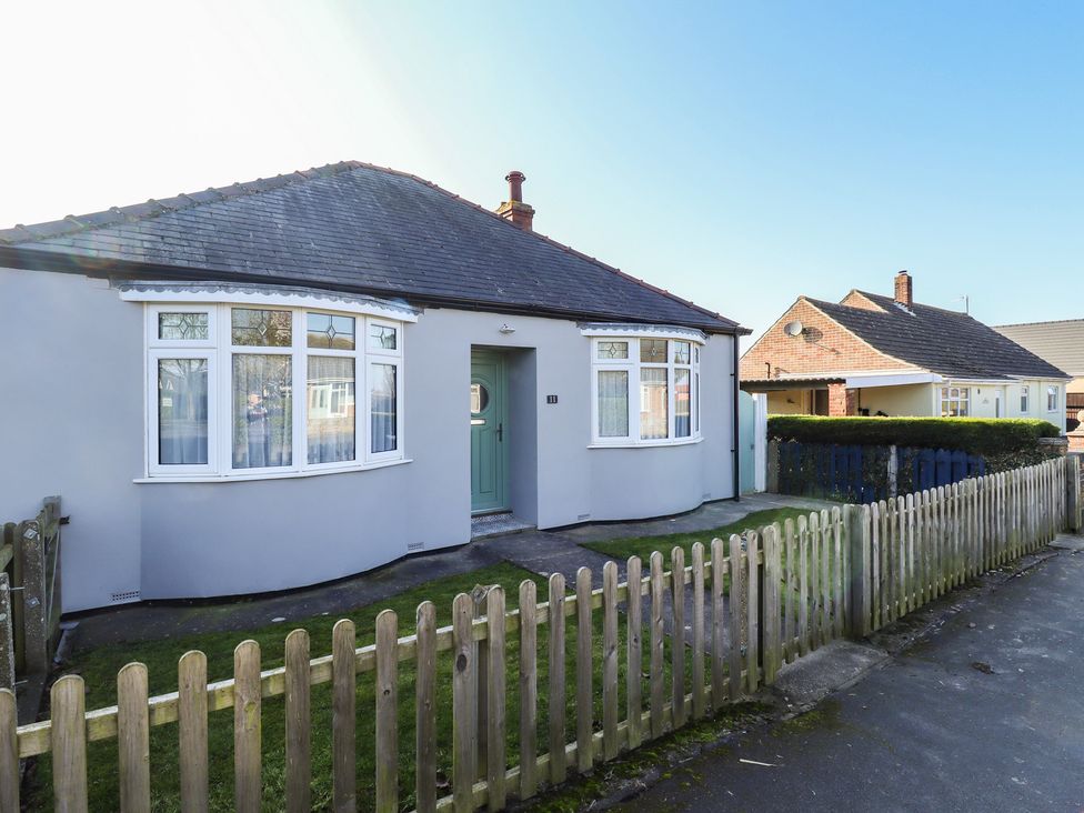 An outdoor view of a bungalow with a blue door at The Seaside Retreat Sutton-On-Sea