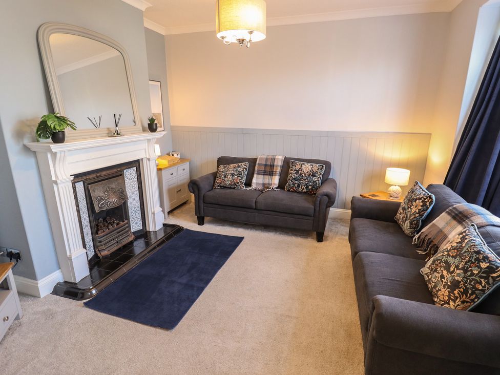 A living room with a sofa and fireplace at The Seaside Retreat in Sutton-On-Sea