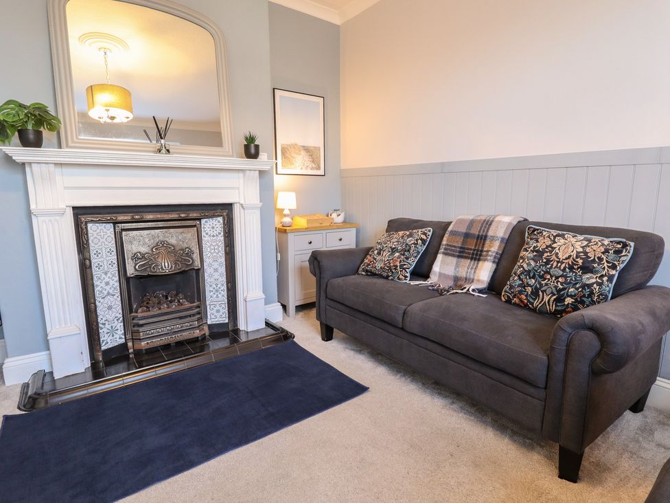 A living room with a fireplace and sofa at The Seaside Retreat in Sutton-On-Sea