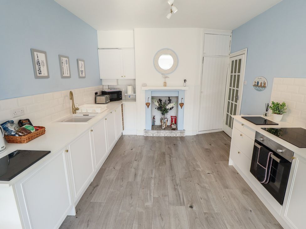 A kitchen with appliances and cabinets at The Seaside Retreat in Sutton-On-Sea