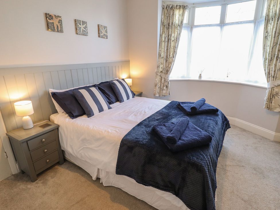 A bedroom with a bed and bedside table at The Seaside Retreat in Sutton-On-Sea
