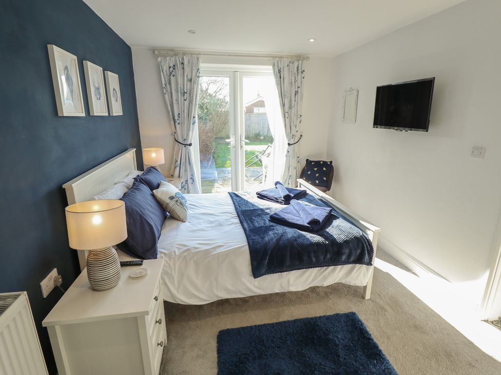 A bedroom with a bed and television at The Seaside Retreat in Sutton-On-Sea