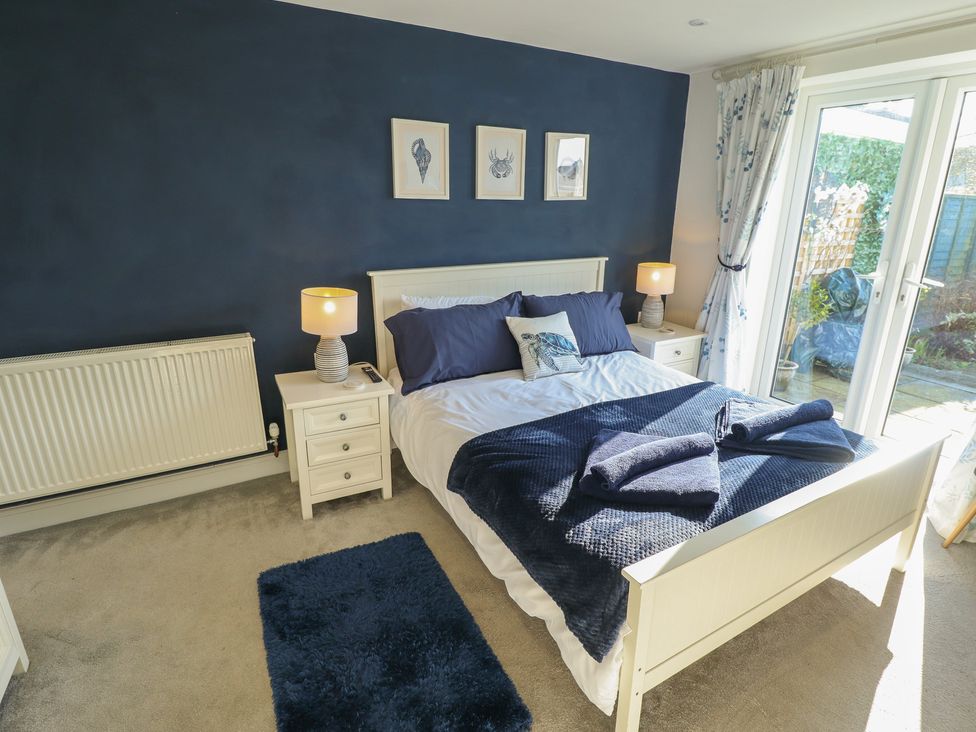 A bedroom with a bed and nightstands at The Seaside Retreat Sutton-On-Sea