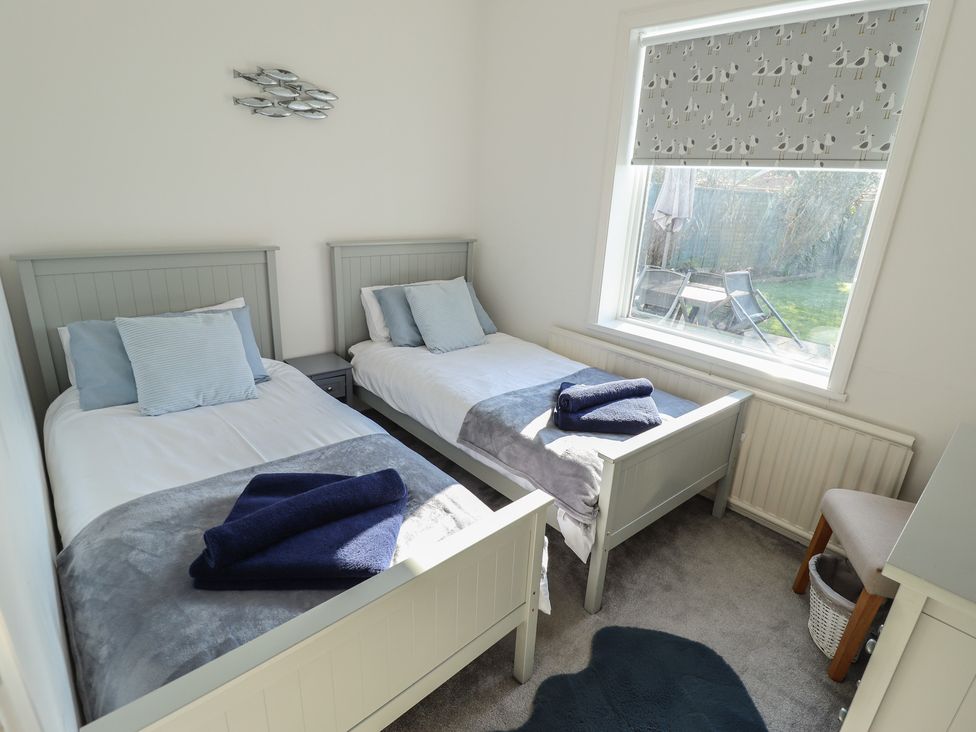 A bedroom with two beds and a window at The Seaside Retreat in Sutton-On-Sea
