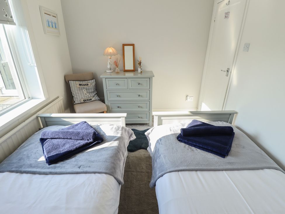 A bedroom with two single beds and a dresser at The Seaside Retreat Sutton-On-Sea