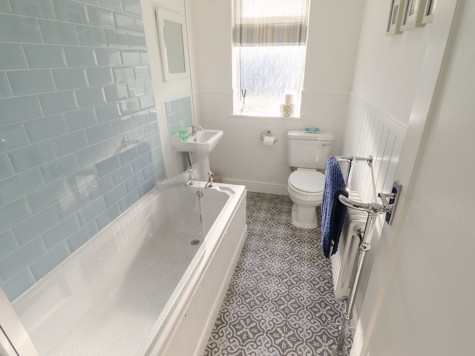 A bathroom with a bathtub, sink, and toilet at The Seaside Retreat in Sutton-On-Sea