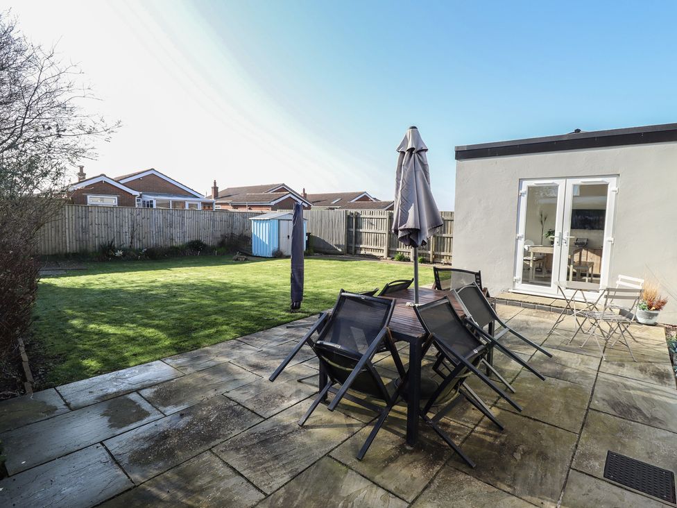 A garden with a table and chairs at The Seaside Retreat Sutton-On-Sea
